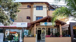A building with a sign for 'K&K' and 'Apartamentos'. - Residencial Ilha Dourada (Florianópolis)