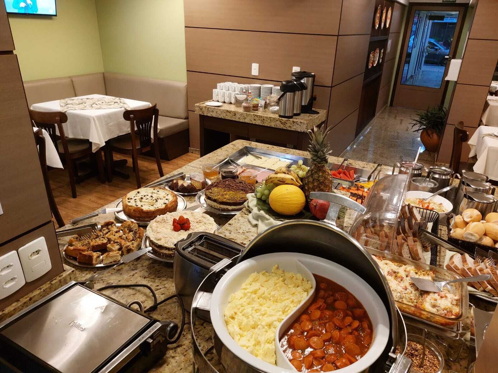 Montaje de bufé con diversos alimentos, como pasteles, frutas y una variedad de platos.