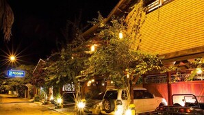 A nighttime street view with parked cars and a building with a sign that reads "POUSADA". - Pousada Enseada dos Búzios (Ubatuba)