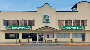 A hotel with a prominent Novotel sign, a central entrance, and a symmetrical facade with windows on both sides. - Novotel (Poza Rica)