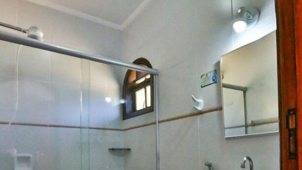 Une salle de bain avec une douche à parois de verre, des toilettes, un lavabo et un panier à linge.