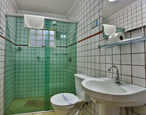 Une salle de bain avec une douche à parois de verre, des toilettes, un lavabo et un miroir.