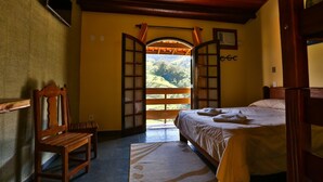 Une chambre avec un lit, une chaise et une vue sur un balcon.