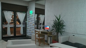 A modern hotel lobby with a reception desk, computer, and seating area. - Hotel Vial Center (Mar del Plata)