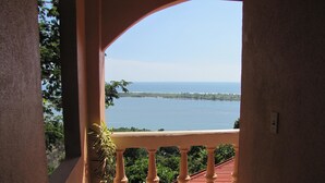 Un balcon donnant sur une étendue d’eau et sur de la verdure.