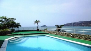 A swimming pool with a view of the ocean and mountains in the background. - Apartamentos Suiteline Master (Santa Marta)