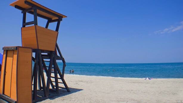 A lifeguard tower on a beach with clear blue water and a few people in the distance. - Apartamentos Suiteline Master (Santa Marta)