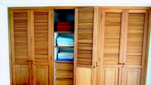 A wooden wardrobe with multiple compartments, including shelves and hanging space. - Apartamentos Suiteline Master (Santa Marta)