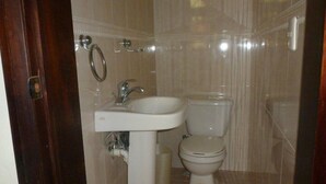 Un baño pequeño y limpio con un lavamanos blanco, un inodoro y un espejo.
