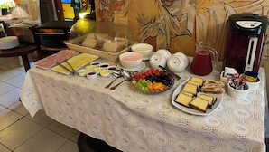Un bufé de desayuno con una variedad de alimentos, entre ellos frutas, pastelería y bebidas.