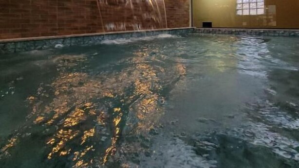 An indoor swimming pool with a wooden ceiling and brick walls. - Pousada Recanto do Aconchego (Florianópolis)