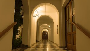 A hallway with a checkered floor, wooden handrails, and a door at the end. - Bremen Hotel & Spa (Villa General Belgrano)