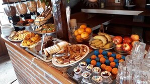 A buffet with various food items including fruits, pastries, and desserts. - Rey del Bosque (Valeria del Mar)