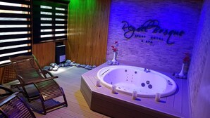 A spa area with a hot tub, wooden deck, and a wall with the text "Royal Bosque". - Rey del Bosque (Valeria del Mar)