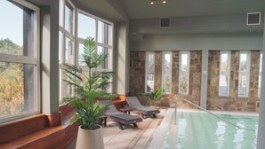 A pool area with lounge chairs and potted plants.