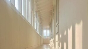 Un largo pasillo estrecho con una serie de escalones que conducen a un nivel superior.