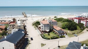 Zona residencial costera con playa, casas y una carretera.