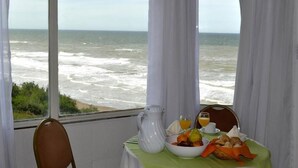 A table with breakfast items and a view of the ocean.