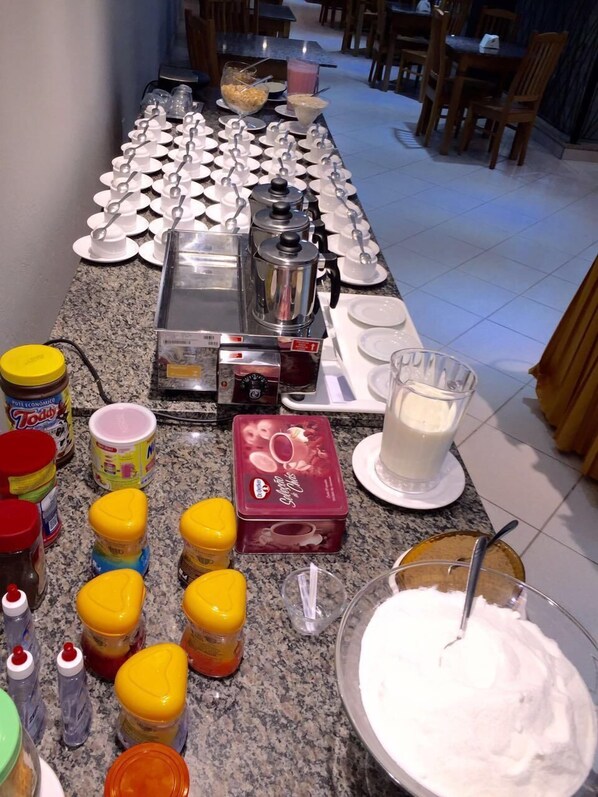 A breakfast buffet setup with various food items and condiments. - Hotel Trilhos de Minas (São João del Rei)