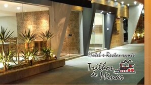 Ein modernes Hotel mit Glasfassade, Sitzgelegenheiten im Freien und dekorativen Pflanzen.