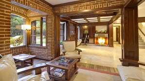A cozy living room with brick walls, a fireplace, and comfortable seating.