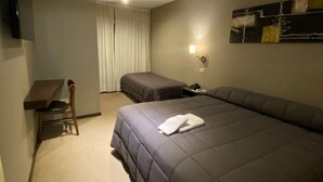 A hotel room with a large bed, a desk, a chair, a bedside table, and a wall-mounted TV. - Hotel Aires de Tandil (Tandil)