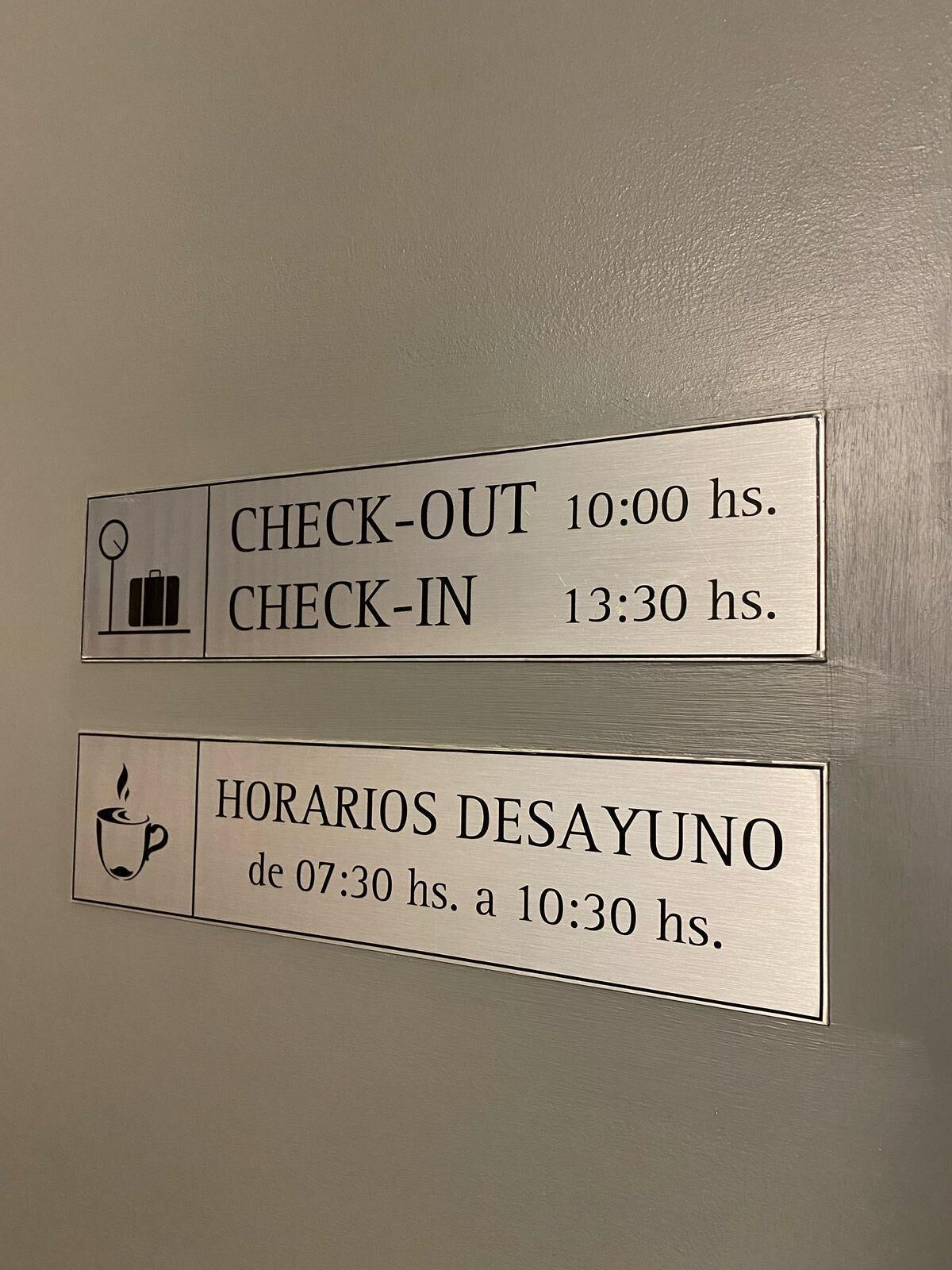 Et skilt med information om udtjekning, indtjekning og kaffepausetider.