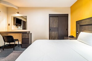 A hotel room with a bed, a desk with a chair, a telephone, and a wardrobe. - Hotel Arizona (Mexico City)
