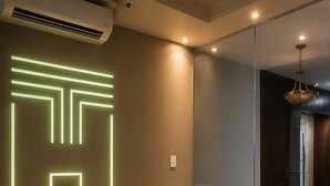 A modern living room with a leather sofa, a wooden coffee table, and a neon light design on the wall. - Terrazzo hotel Campos dos Goytacazes (Campos)