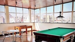 A pool table in a room with large windows and a view of the cityscape. - Terrazzo hotel Campos dos Goytacazes (Campos)