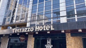 A modern hotel with a glass facade, a prominent sign reading 'Terrazzo Hotel,' and a stone base. - Terrazzo hotel Campos dos Goytacazes (Campos)