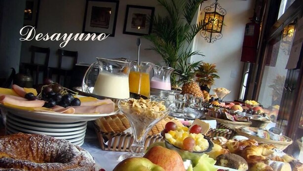 A breakfast buffet with various fruits, pastries, and beverages. - Apart Hotel Della Riviera (San Bernardo del Tuyú)