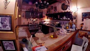 A cozy, vintage-style kitchen with wooden cabinets, a wooden ceiling, and a variety of kitchenware displayed on shelves. - Apart Hotel Della Riviera (San Bernardo del Tuyú)