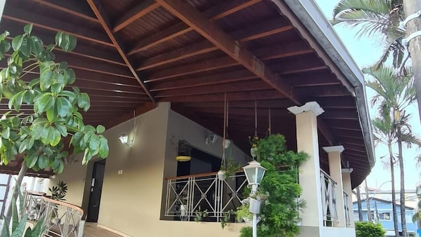 Un espacio exterior techado con techo de madera, una escalera y plantas en macetas.