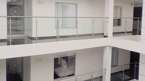 A multi-level interior with glass railings and white walls. - Hotel Dorado Gold Prime (Bogota)