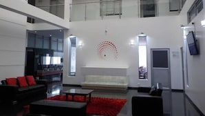 A modern interior with a living area, a staircase, and a dining area. - Hotel Dorado Gold Prime (Bogota)