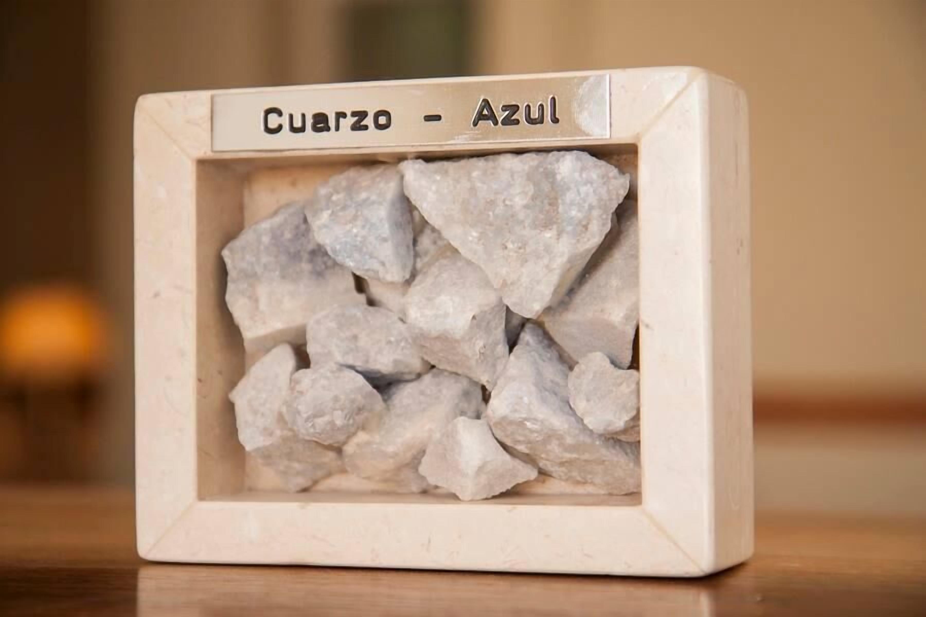 Una vitrina con una colección de rocas blancas etiquetadas 'Cuarzo - Azul'.