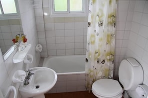 Uma casa de banho com banheira, lavatório e sanita.