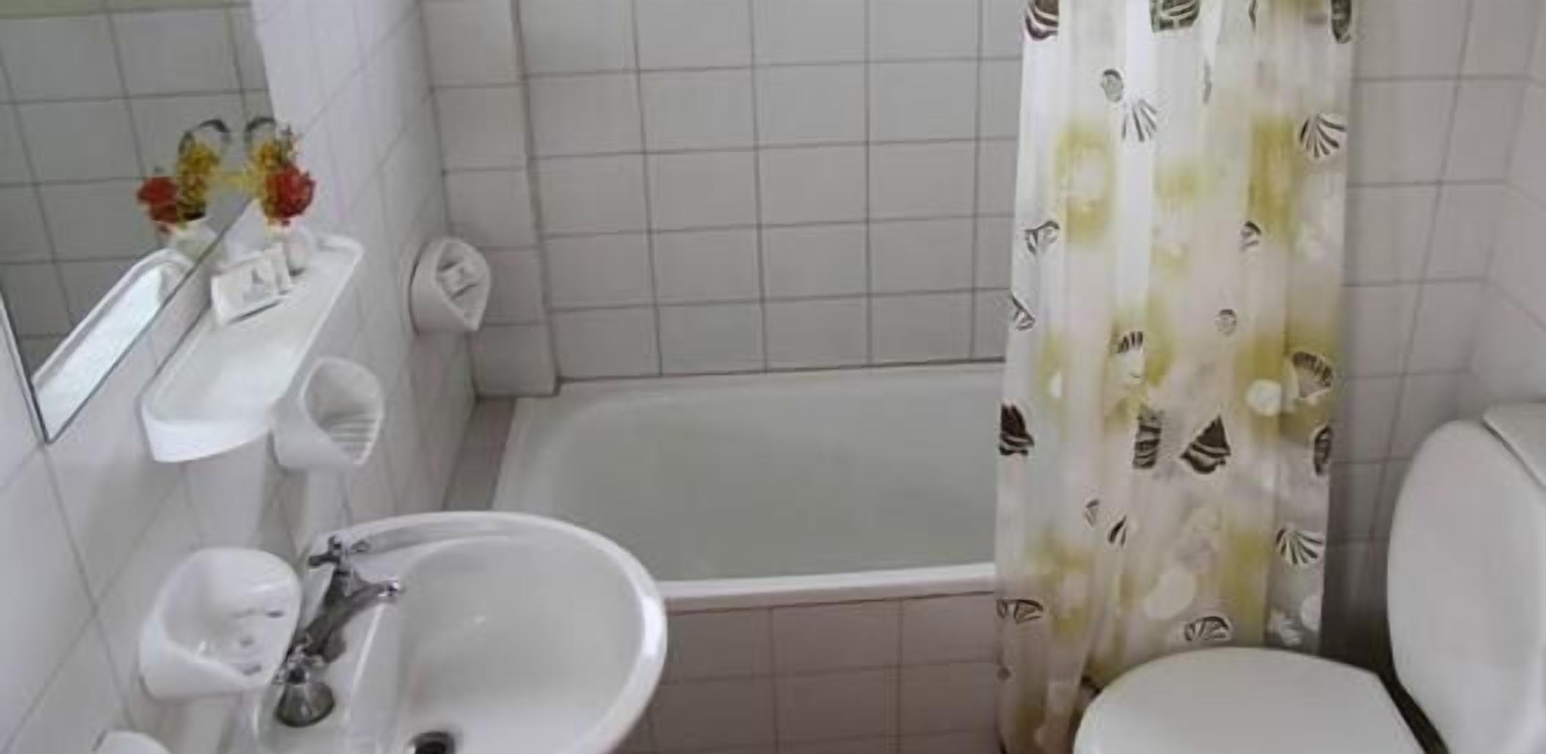 A bathroom with a bathtub, a sink, and a toilet.