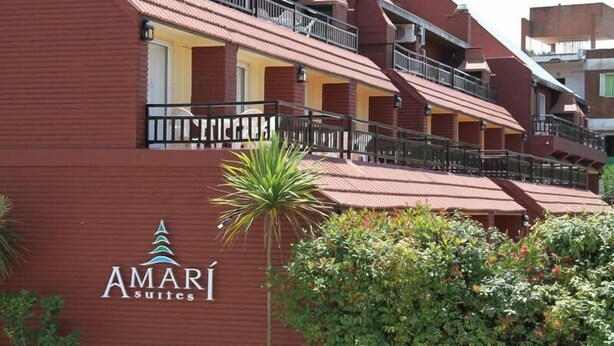 Et hotel med flere etager, altaner og et skilt med 'AMARI Suites'.