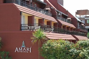 A multi-story hotel with balconies and a sign for 'AMARI Suites'. - Amari Suites (Pinamar)