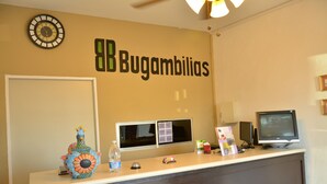 A reception desk with a clock, a computer monitor, and a wall sign reading "Bugambilias". - Hotel Bugambilias (Cajeme)