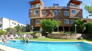 A hotel with a swimming pool, a covered outdoor area, and a brick facade. - Hotel Casablanca Mina Clavero (Mina Clavero)