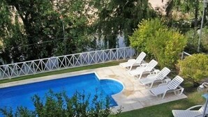 A swimming pool with white lounge chairs and a white fence surrounding it. - Hotel Casablanca Mina Clavero (Mina Clavero)