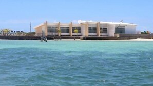 Een modern gebouw met grote ramen, aan het water gelegen.