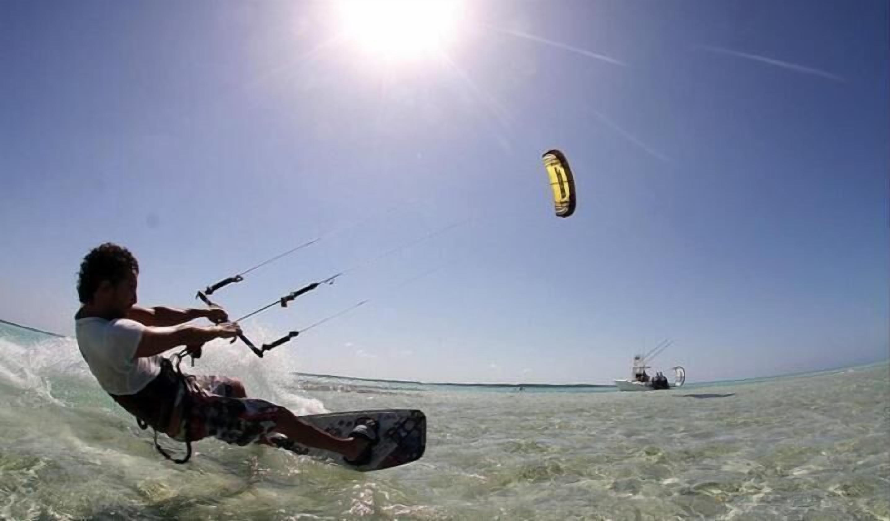 Eine Person windsurft an einem sonnigen Tag.