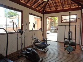 A gym with exercise equipment, including treadmills, stationary bikes, and a weight bench.