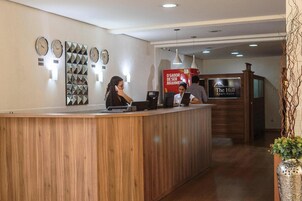 A reception desk with clocks, a sign for 'The Hill Apart Suite', and a wooden counter.