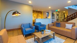 A modern living room with a sofa, two armchairs, a coffee table, and a floor lamp.