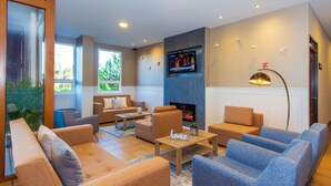 A modern living room with sofas, a coffee table, and a fireplace.